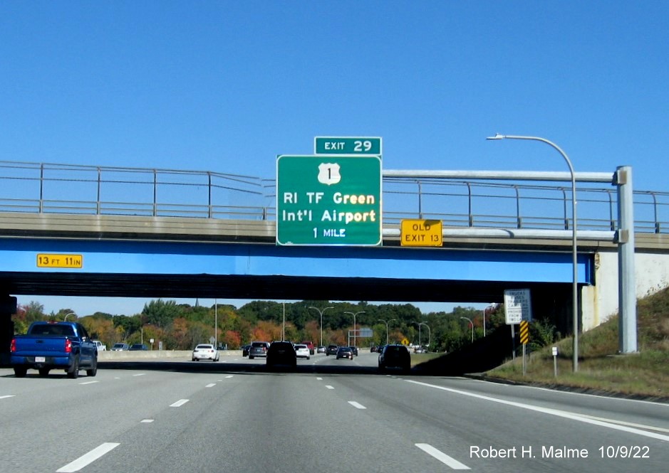 Image of 1 mile advance overhead sign for US 1/T.F. Green Airport exit with new milepost based exit number and yellow Old Exit 13 sign on gantry arm on I-95 North in Warwick, October 2022