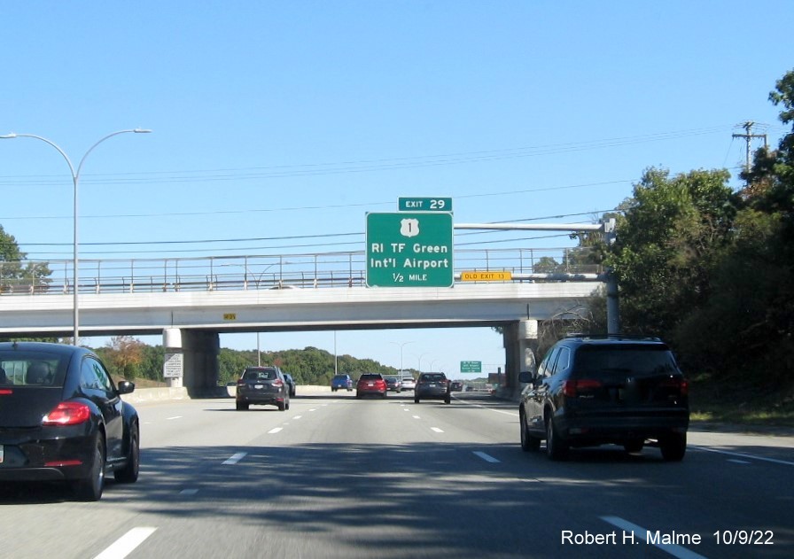 Image of 1/2 mile advance overhead sign for US 1/T.F. Green Airport exit with new milepost based exit number and yellow Old Exit 13 sign on gantry arm on I-95 North in Warwick, October 2022