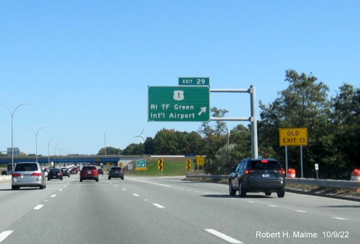 Image of overhead exit sign for US 1/T.F. Green Airport exit with new milepost based exit number and yellow Old Exit 13 sign on gantry arm on I-95 North in Warwick, October 2022