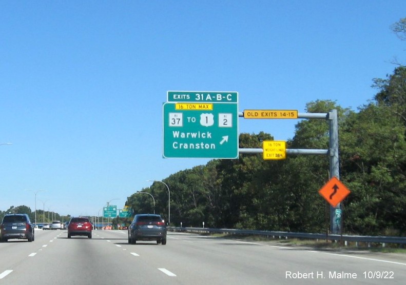 Image of overhead ramp sign for RI 37 and Jefferson Blvd. exits with new milepost based exit numbers and yellow Old Exits 14-15 sign on gantry arm on I-95 North in Warwick, October 2022