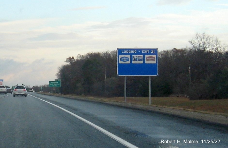 Image of ground mouted blue lodging services sign for Coventry/West Warwick exit with new milepost based exit number on I-95 North, November 2022