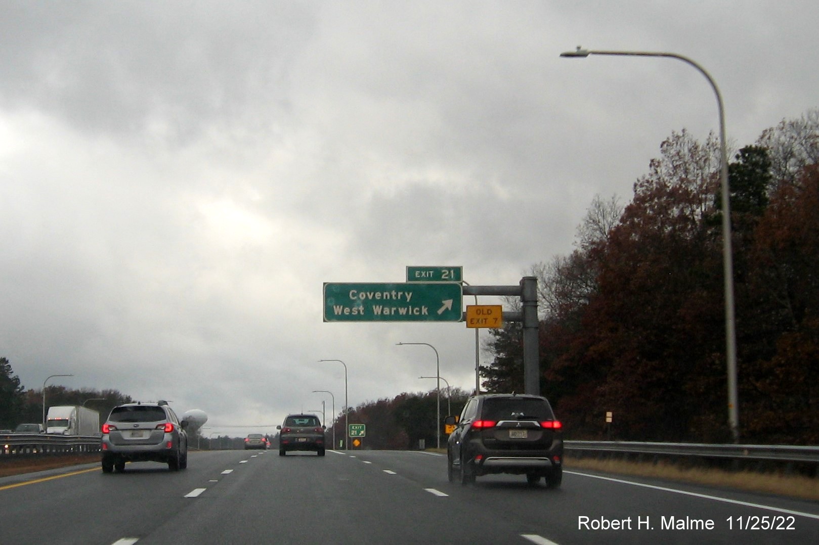Image of overhead ramp sign for Coventry/West Warwick exit with new milepost exit number and yellow Old Exit 7 sign above exit tab, on I-95 South, November 2022