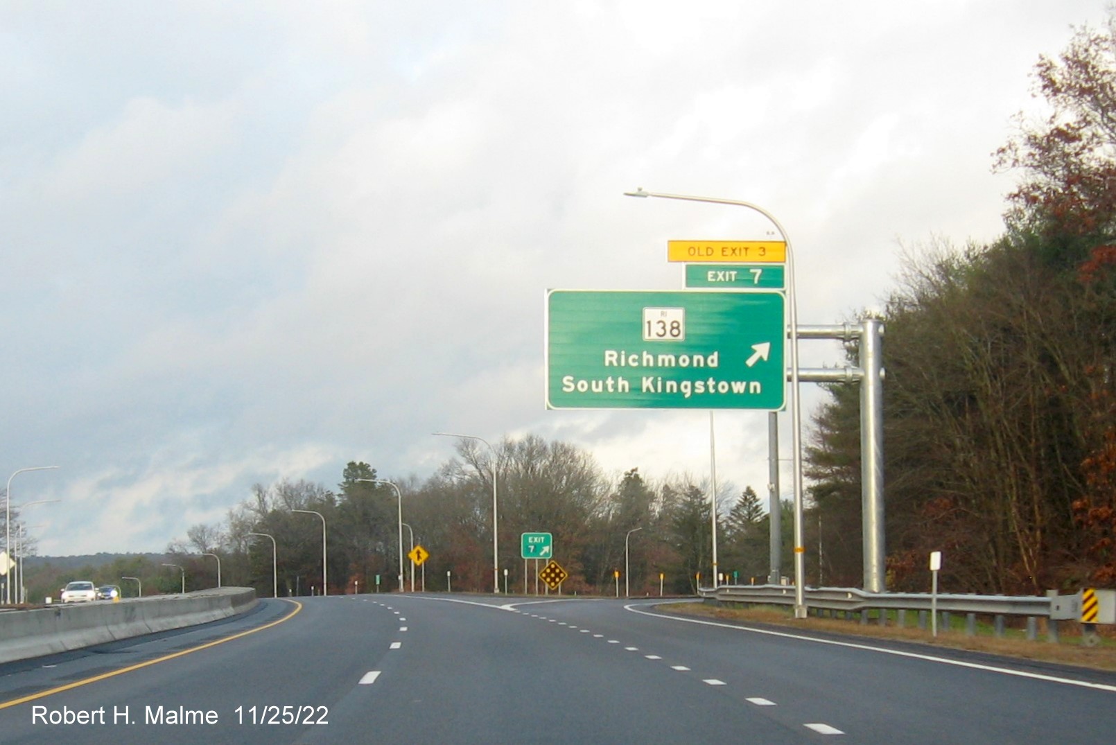 Image of overhead ramp sign for RI 138 exit with new milepost based exit number and 
                                         yellow Old Exit 3 sign above exit tab on I-95 North in Wyoming, November 2022