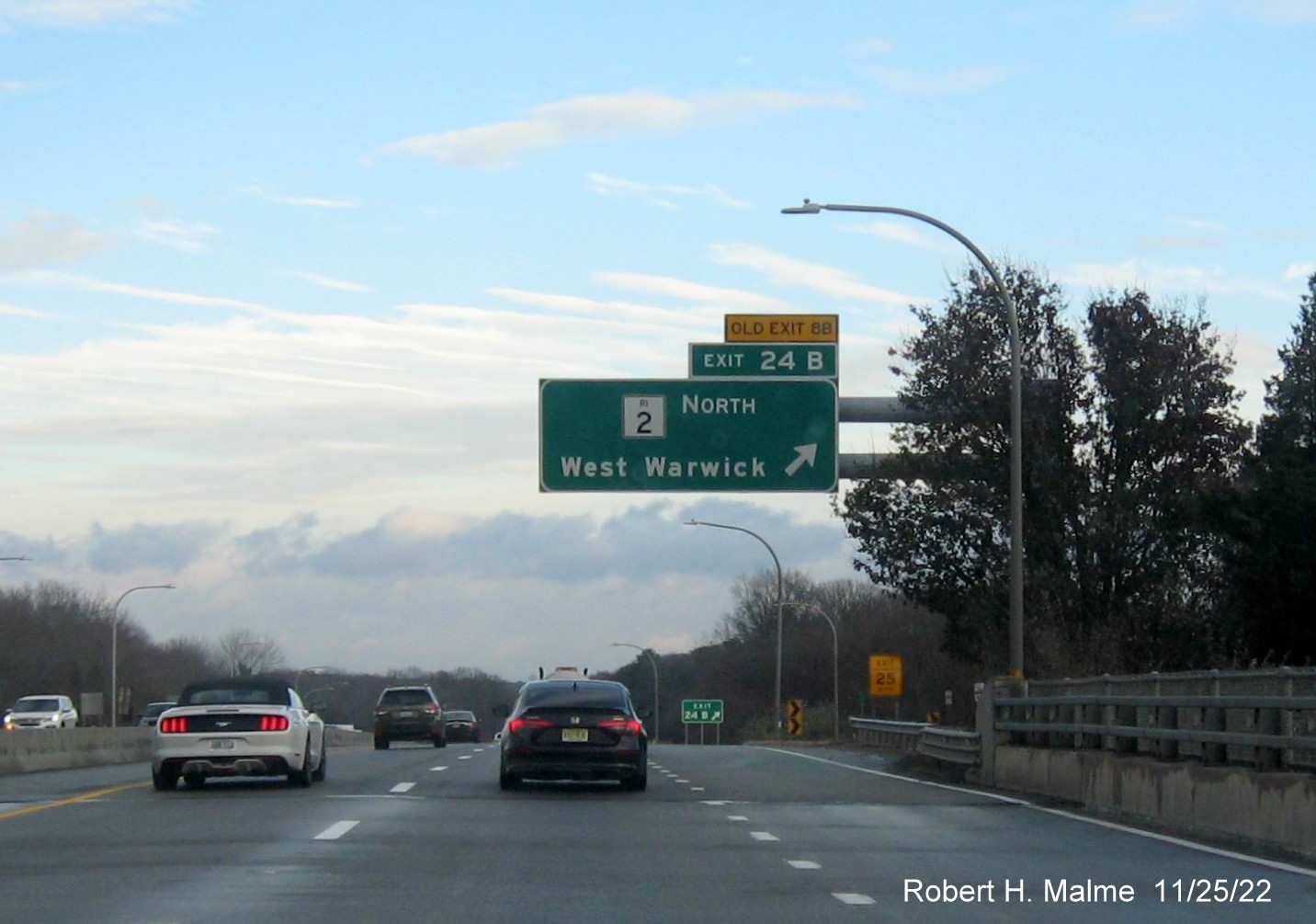 Image of overhead ramp sign for RI 2 North exit with new milepost based exit number and yellow Old Exit 8B sign above exit tab on I-95 North in West Warwick, November 2022
