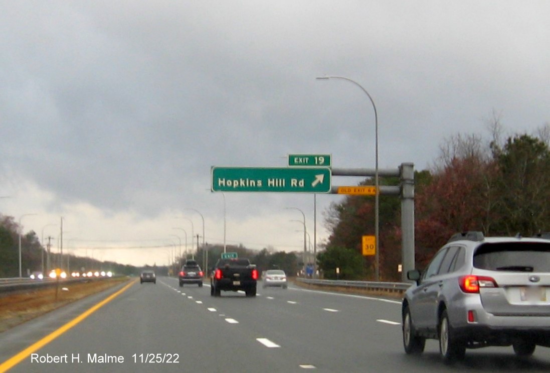 Image of 1 mile advance sign for Old Hopkins Road exit with new milepost exit number, and yellow Old Exit 6A sign on gantry arm, on I-95 South in West Warwick, November 2022