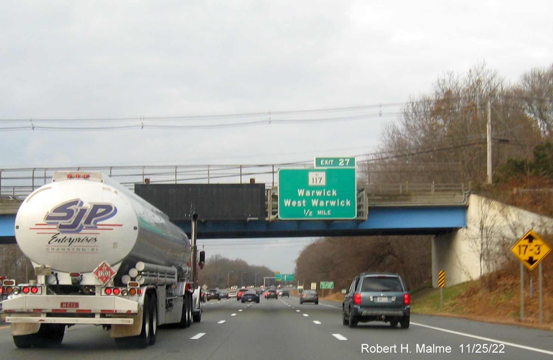 Image of overhead 1/2 mile advance sign for RI 117 exit with new milepost based exit number and yellow Old Exit 10 sign on gantry arm on I-95 North in West Warwick, November 2022