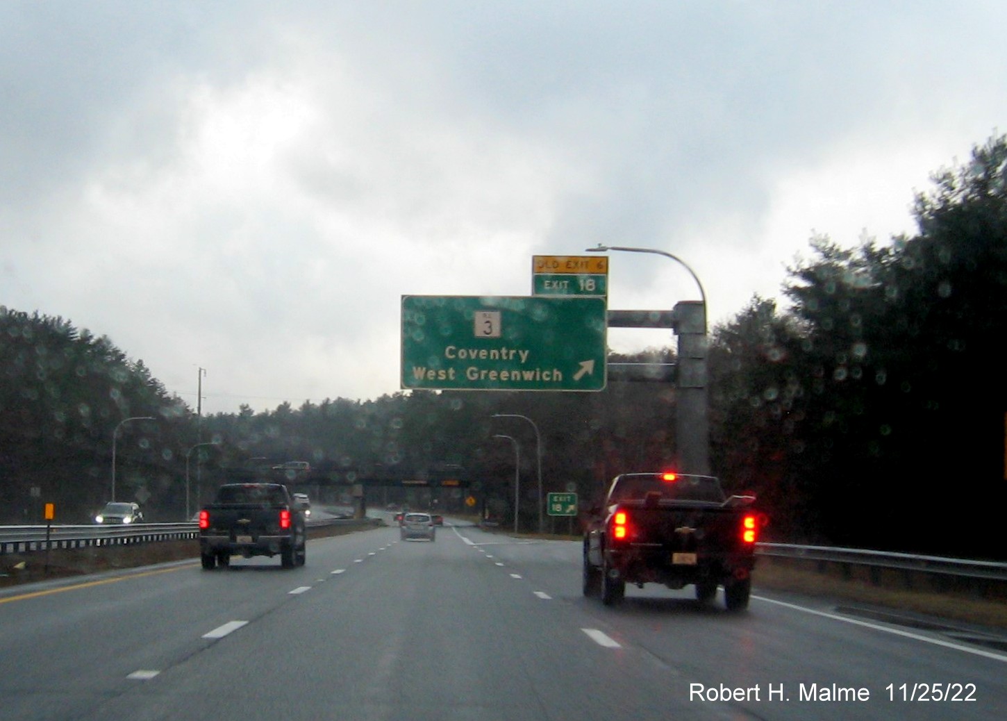 Image of overhead ramp sign for RI 3 exit with new milepost exit number, and yellow Old Exit 6 sign above exit tab, on I-95 South, November 2022