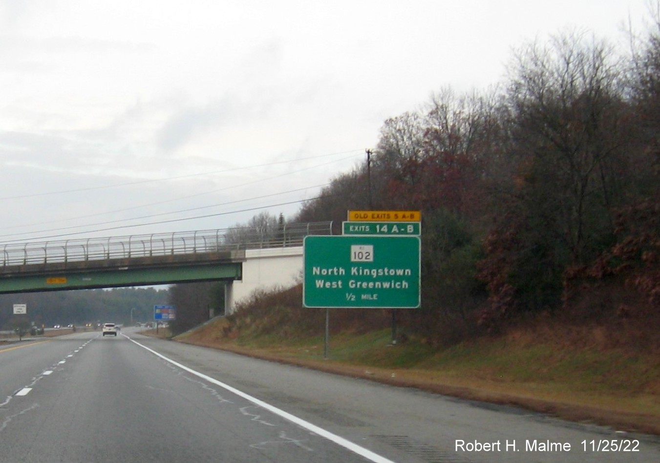 Image of ground mounted 1/2 mile advance sign for RI 102 exits with new milepost based exit numbers and yellow Old Exits 5 A-B advisory sign over exit tab on I-95 North in West Greenwich, November 2022