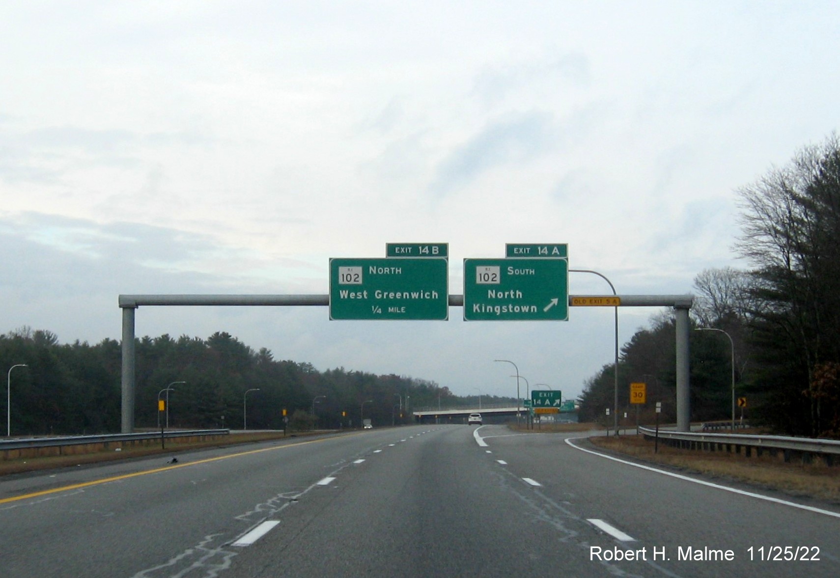 Image of overhead signage at RI 102 South exit ramp with new milepost based exit numbers and yellow Old Exits 5A advisory sign on gantry arm on I-95 North in West Greenwich, November 2022