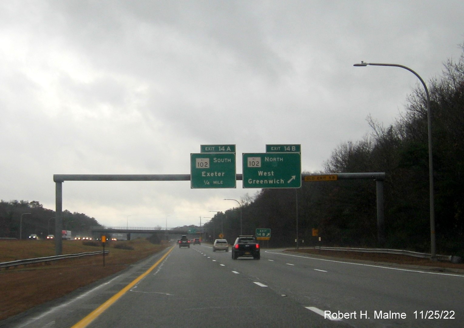 Image of overhead signage at ramp for RI 102 North exit with new milepost based exit numbers and yellow Old Exits 5B sign on gantry arm on I-95 South in West Greenwich, November 2022