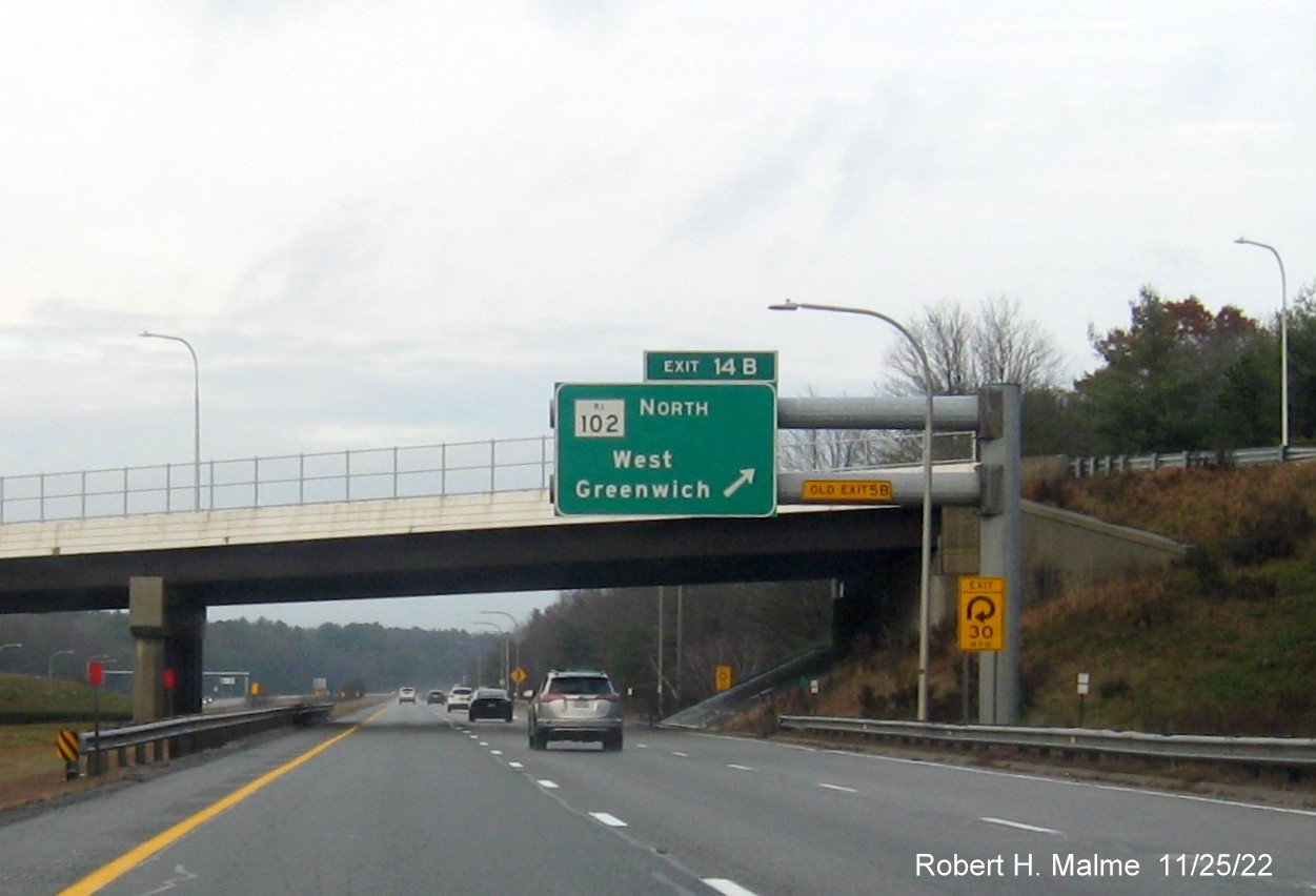 Image of overhead ramp sign for RI 102 North exit with new milepost based exit numbers and yellow Old Exit 5B advisory sign on gantry arm on I-95 North in West Greenwich, November 2022