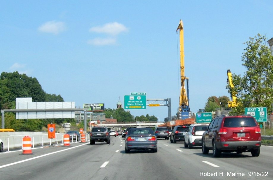 Image of 1 mile advance overhead sign for RI 146 / US 44 exits with new milepost based exit numbers and yellow Old Exit 23 sign on gantry arm on I-95 North in Providence, September 2022