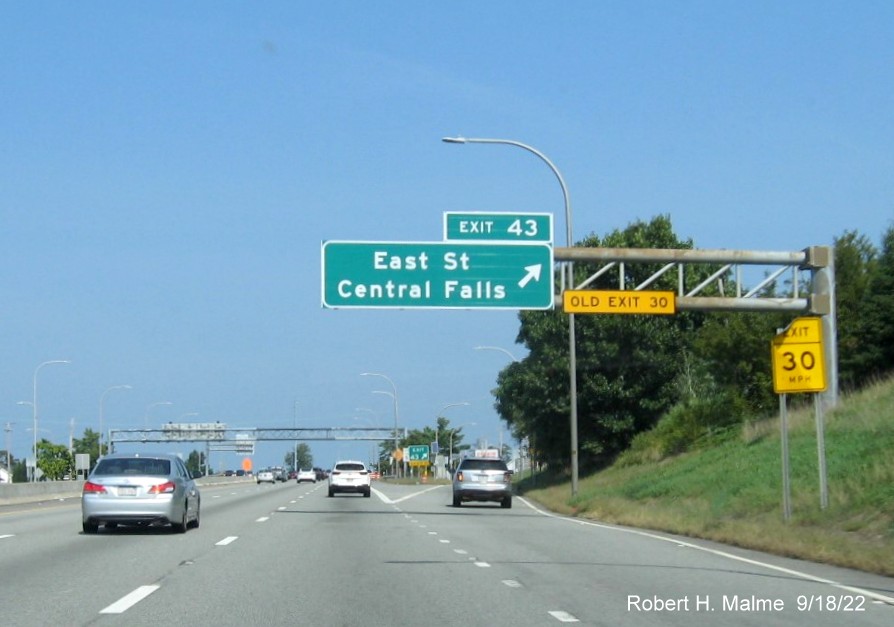 Image of overhead ramp sign for East Street exit with new milepost based exit number and yellow Old Exit 30 sign on I-95 North in Pawtucket, September 2022