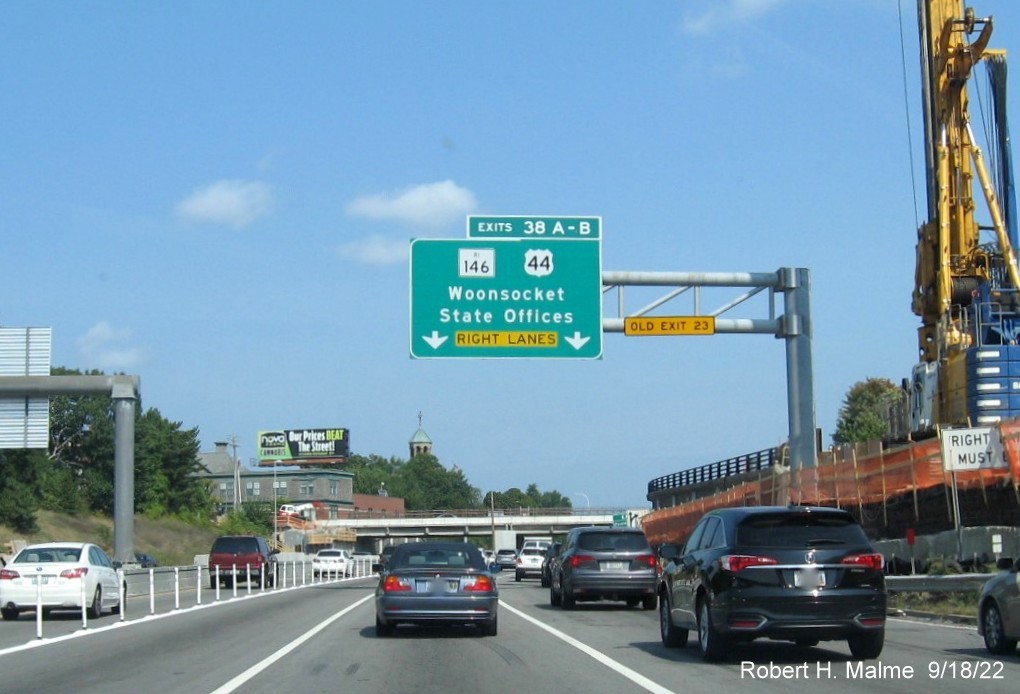 Image of 1/2 mile advance overhead sign for RI 146 / US 44 exits with new milepost based exit numbers and yellow Old Exit 23 sign on gantry arm on I-95 North in Providence, September 2022