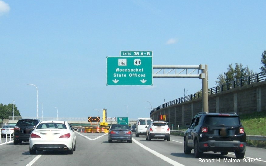 Image of overhead ramp sign for RI 146 / US 44 exits with new milepost based exit numbers and yellow Old Exit 23 sign on gantry arm on I-95 North in Providence, September 2022