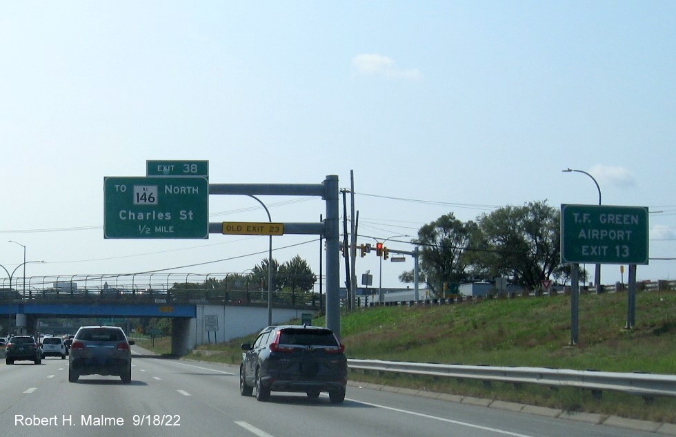 Image of 1/2 mile advance overhead sign for Charles Street exit with new milepost based exit number and yellow Old Exit 23 sign on support arm, September 2022 e