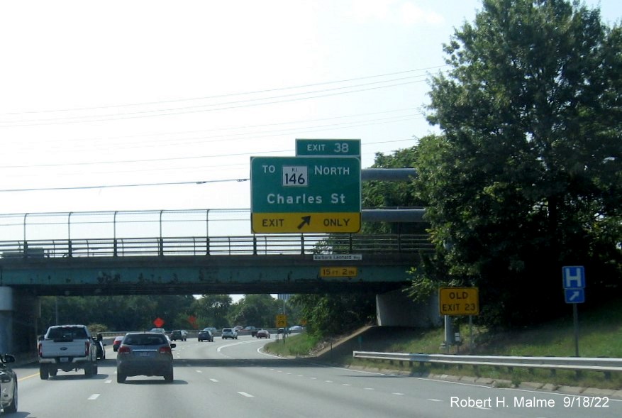 Image of overhead ramp sign for Charles Street exit with new milepost based exit number and yellow Old Exit 23 sign on support arm, September 2022 e