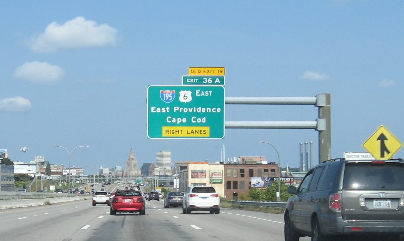 Image of 2 miles advance overhead sign for I-195/US 6 East exit with new milepost based exit number and yellow Old Exit 19 sign on top of exit tab on I-95 North in Providence, September 2022