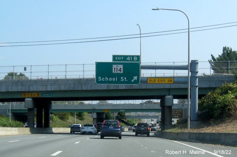 Image of overhead ramp sign for RI 114 exit with new milepost based exit number and yellow Old Exit 28 sign on gantry arm, September 2022