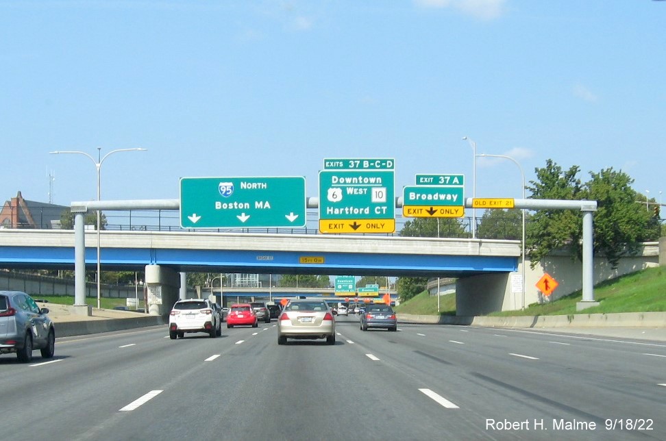 Image of overhead signage at ramp for Broadway exit with new milepost based exit numbers and yellow Old exit number tab on gantry on I-95 North in Providence, September 2022