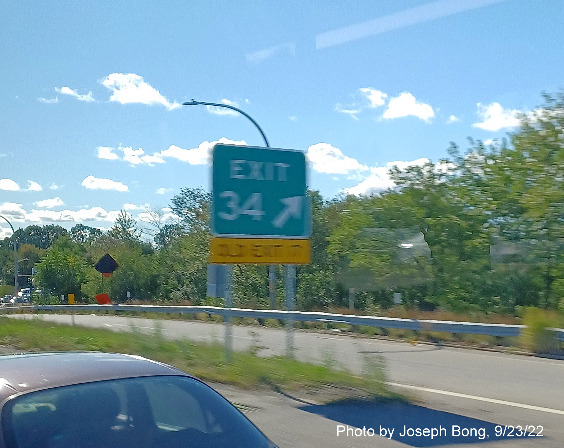 Image of gore sign for US 1/Elmwood Avenue exit with new milepost based exit number and yellow Old Exit 17 sign below on I-95 South in Providence, by Joseph Bong, September 2022