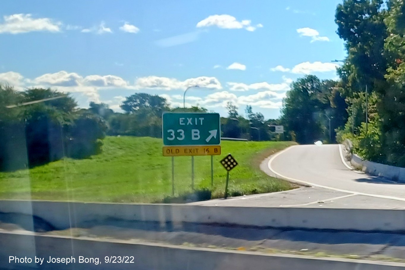 Image of gore sign for RI 10 North exit with new milepost based exit number and yellow Old Exit 16B sign below on I-95 South in Cranston, by Joseph Bong, September 2022