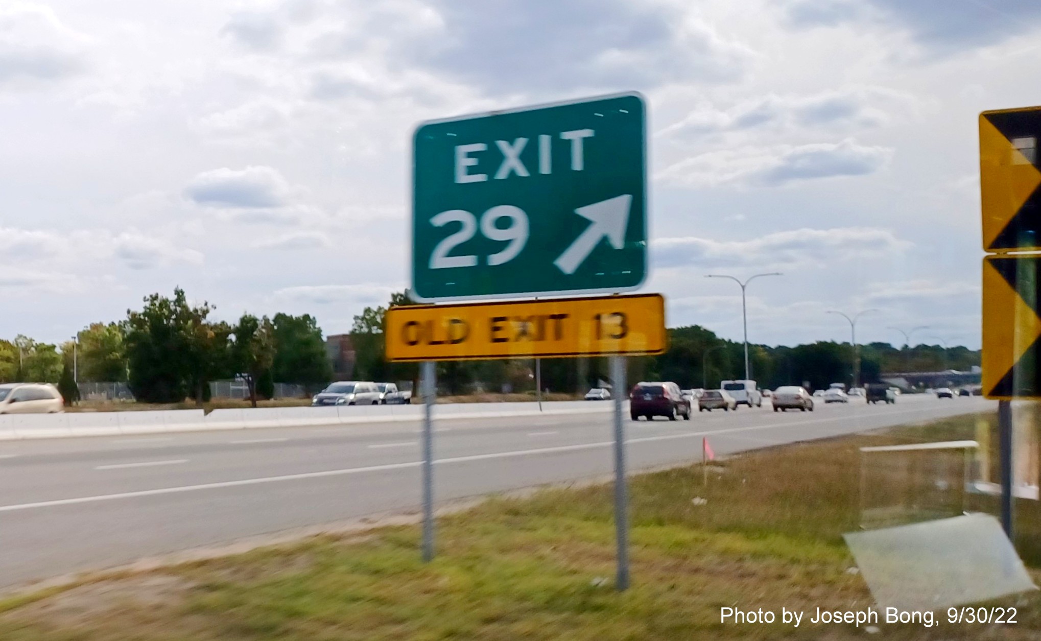 Image of gore sign on I-95 South in Warwick for T.F. Green Airport/US 1 exit with new milepost based exit number and yellow Old Exit 13 sign below, photo by Joseph Bong, September 2022