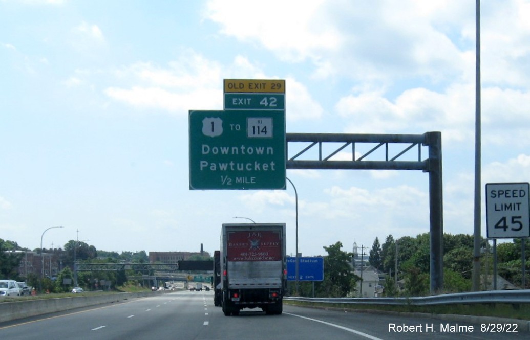Image of 1/2 mile advance overhead sign for US 1 to RI 114 exit with new milepost based exit number and 
                                          yellow Old Exit 29 sign placed above the exit tab on I-95 South in Pawtucket, August 2022