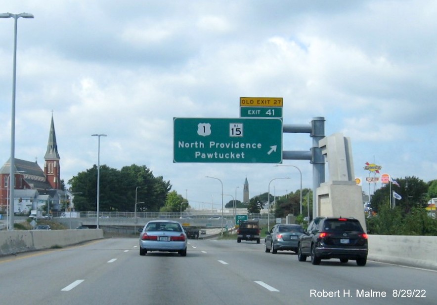 Image of overhead ramp and gore signs for US 1/RI 15 exit with new milepost based exit number 
      and yellow Old Exit 27 signs on I-95 South in Pawtucket, August 2022