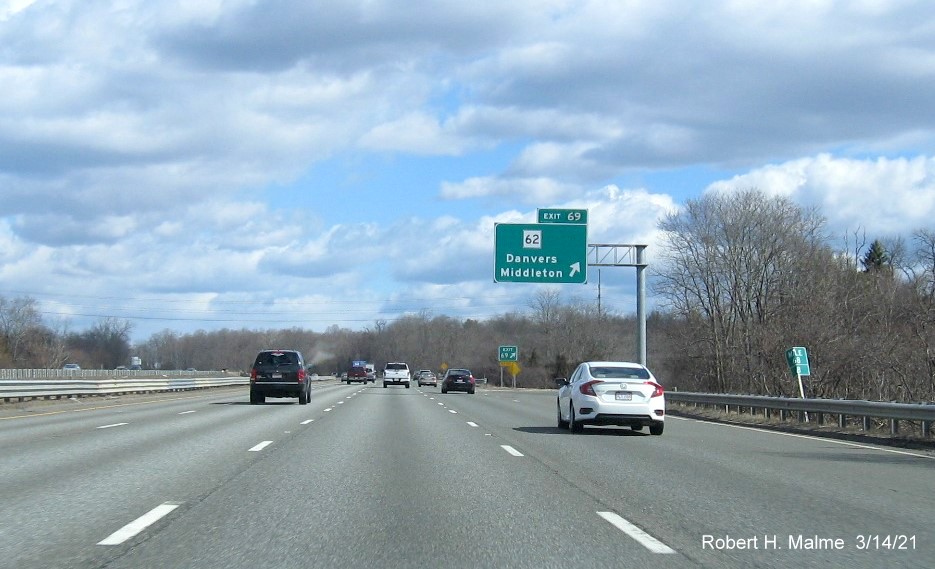 Image of overhead ramp sign for MA 62 exit with new milepost based exit number and gore sign with new number and yellow old Exit 49 advisory sign on support on I-95 North in Danvers, March 2021