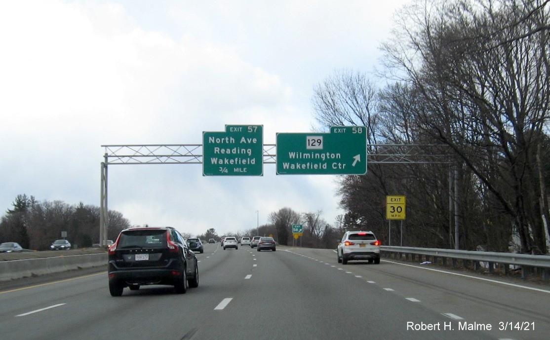 Image of overhead signage at ramp for MA 129 exit with new milepost based exit numbers on I-95 South in Wakefield, March 2021