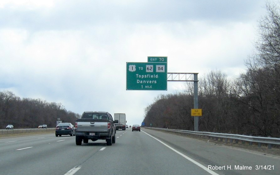 Image of 1-mile advance overhead sign for US 1 exit with new milepost based exit number and yellow old exit advisory sign on support on I-95 South in Danvers, March 2021