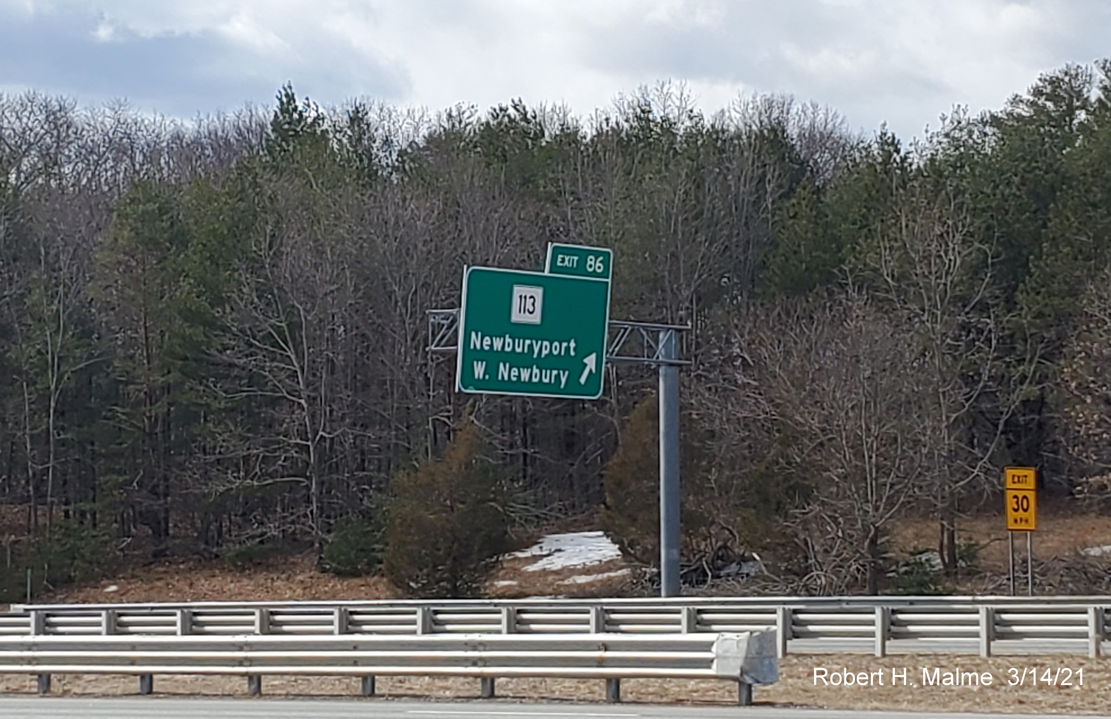 Image of overhead ramp sign for MA 113 exit with new milepost based exit number on I-95 South in Newburyport, March 2021