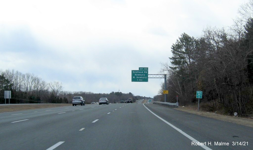 Image of 1-mile advance overhead sign for Scotland Road exit with new milepost based exit number and yellow Old Exit 56 sign on support on I-95 South in Newbury, March 2021