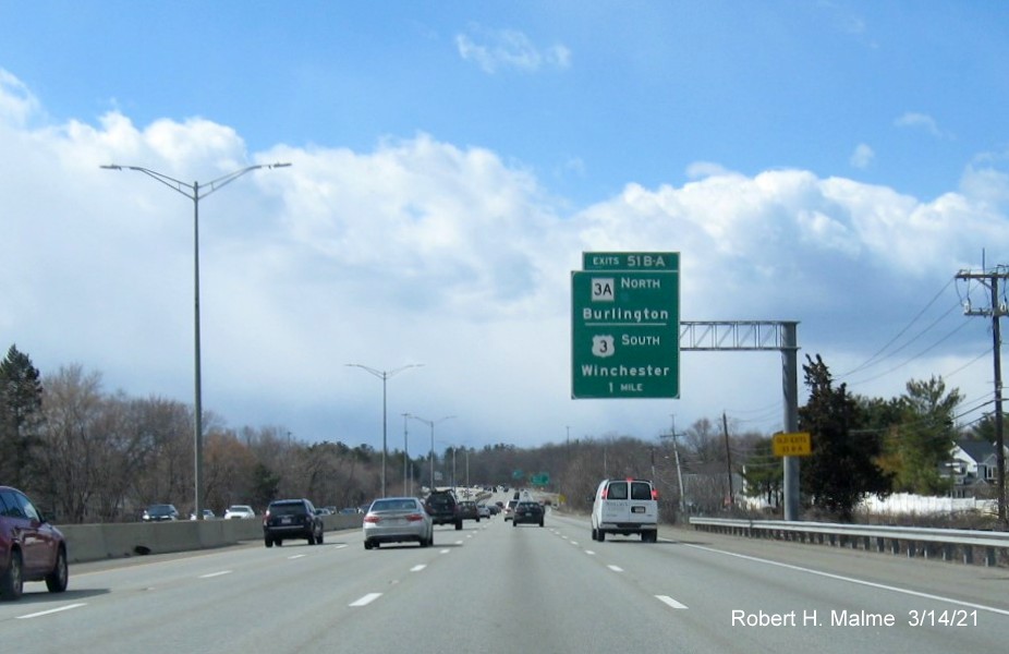 Image of 1-Mile advance for US 3/MA 3A exits with new milepost based exit number and yellow Old Exit 33 B/A advisory sign on support on I-95/MA 128 South in Burlington, March 2021
