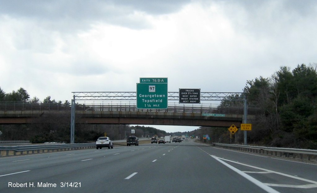 Image of 1 1/4 Mile advance overhead sign for MA 97 exit with new milepost based exit number and yellow Old Exit 54 sign on support on I-95 South in Georgetown, March 2021