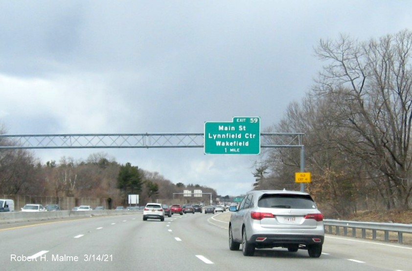 Image of 1 mile advance overhead sign for Main Street exit with new milepost based exit number and yellow Old Exit 40 sign on right support on I-95/MA 128 South in Wakefield, March 2021