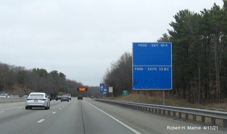 Image of blank blue Food Service sign for Kendrick Street and Highland Avenue exits with new milepost 
                                            based exit numbers on I-95/MA 128 North in Needham, April 2021
