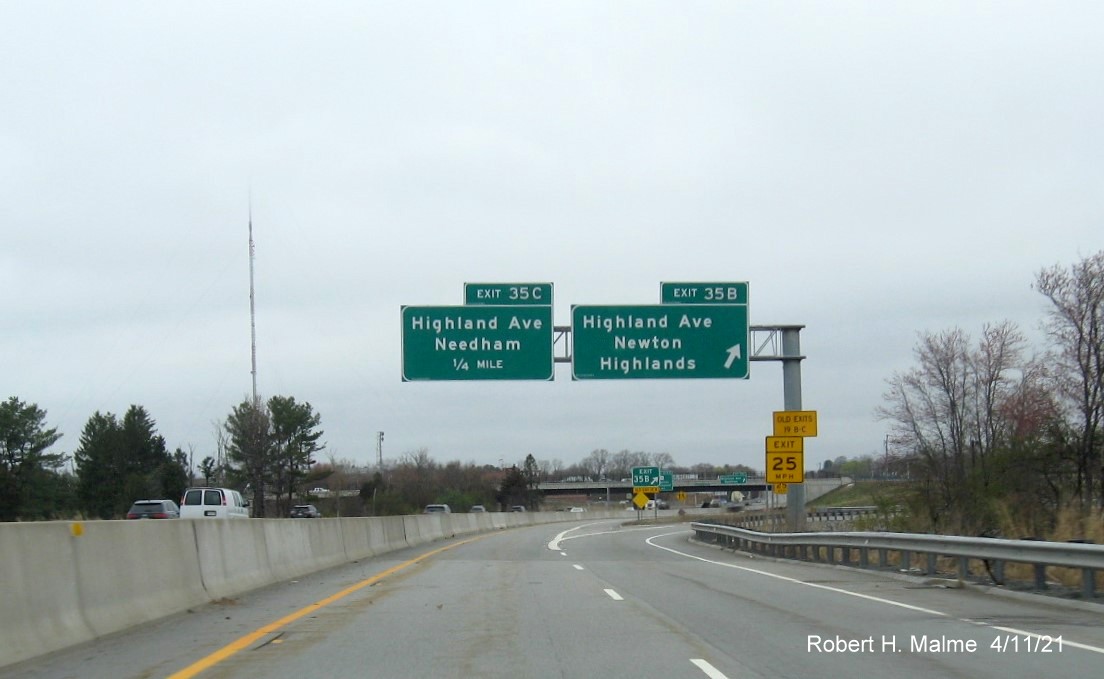 Image of overhead signs at ramp for Highland Avenue East exit with new milepost 
                                            based exit numbers gore sign with new number and yellow Old exit sign below on C/D ramp from I-95/MA 128 North in Needham, April 2021