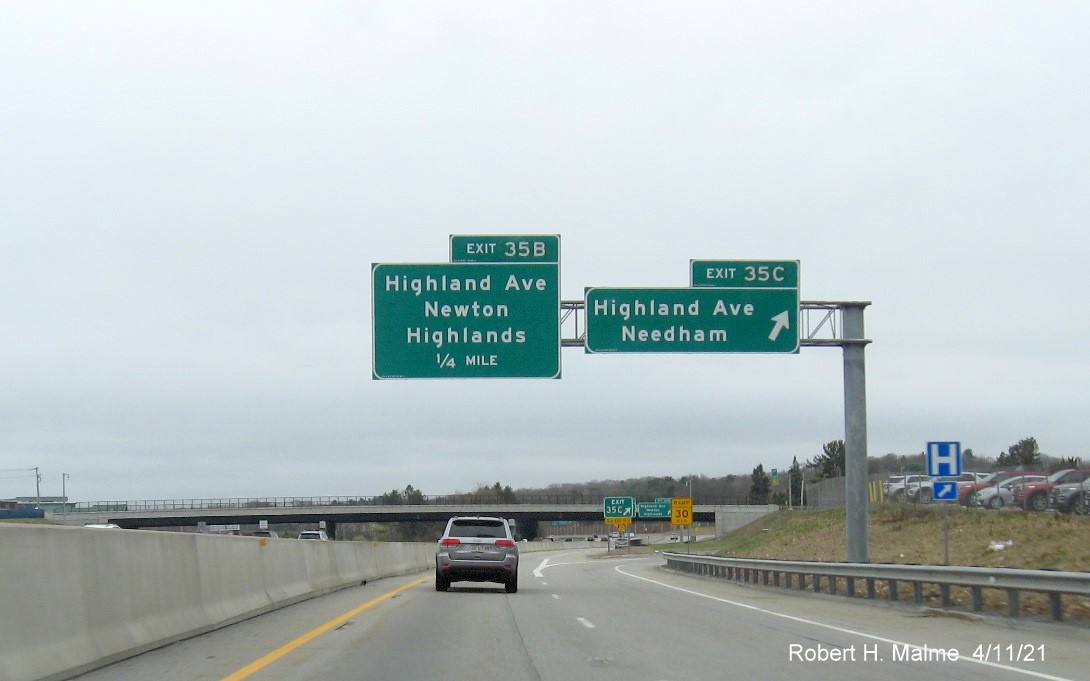 Image of overhead ramp sign for Highland Avenue exits with new milepost based 
                                            exit numbers on C/D ramp from I-95/MA 128 South in Needham, April 2021