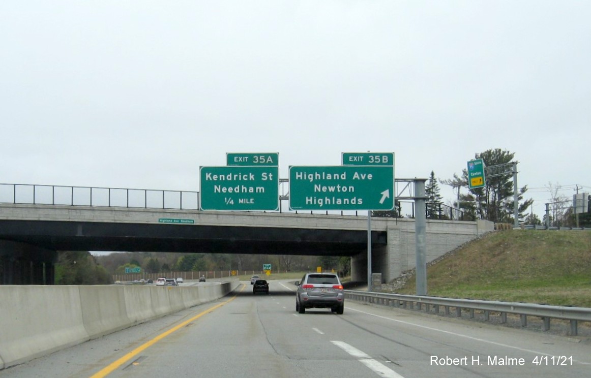 Image of overhhead signs for Highland Avenue East and Kendrick Street exits with new milepost based 
                                            exit numbers on C/D ramp from I-95/MA 128 South in Needham, April 2021