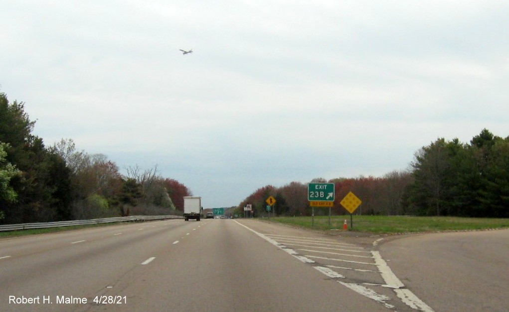 Image of gore sign for Neponset Street, Norwood exit with new milepost based exit number and yellow Old Exit 11B sign attached below on I-95 North in Norwood, April 2021
