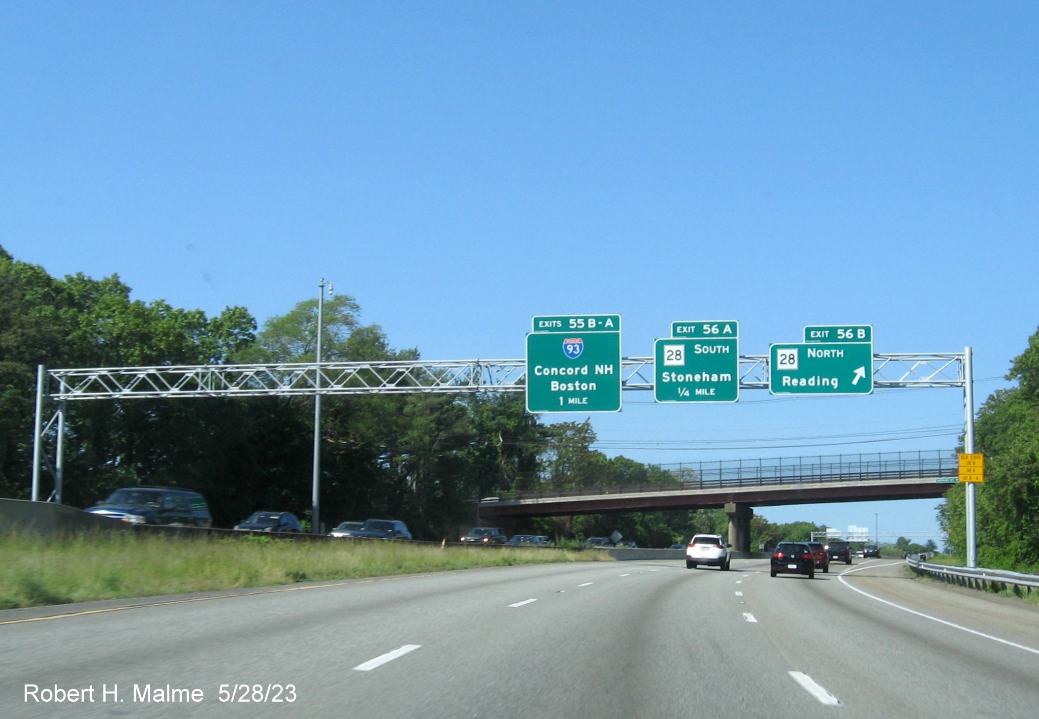 Image of recently placed overhead signage for MA 28 and I-93 exits at ramp for MA 28 North on I-95 South 
        in Reading, May 2023