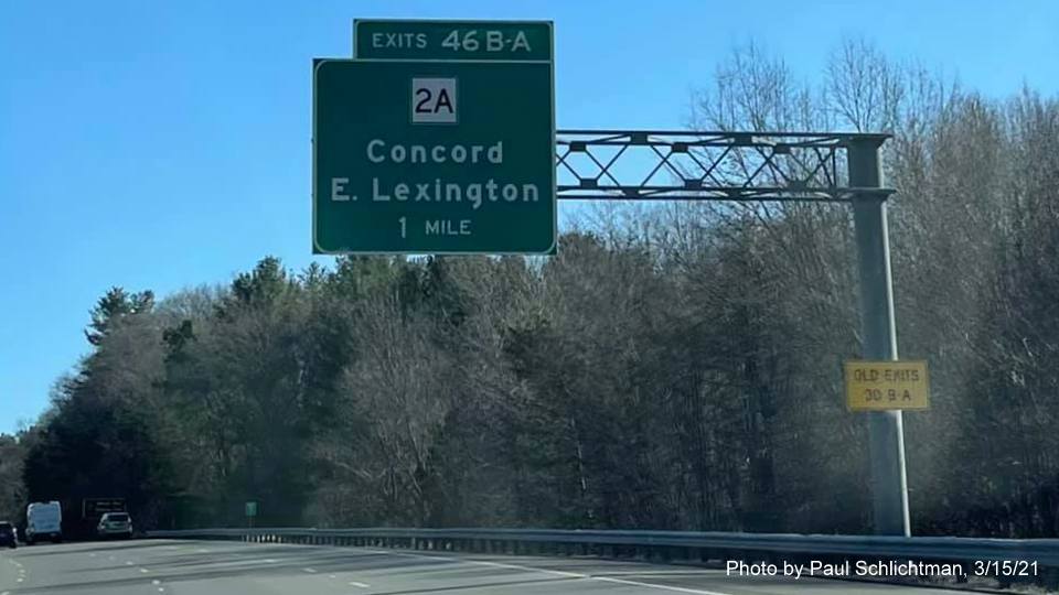 Image of 1 Mile advance overhead sign for MA 2A exits with new milepost based exit number and yellow Old Exits 30 B-A sign on support on I-95/MA 128 South in Lexington, photo by Paul Schlictman, March 2021