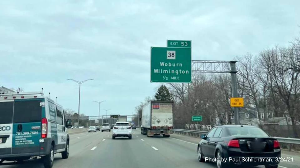 Image of 1/2 mile advance overhead sign for MA 38 exit with new milepost based exit number and yellow Old Exit 35 advisory sign on support on I-95/MA 128 North in Woburn, by Paul Schlichtman, March 2021