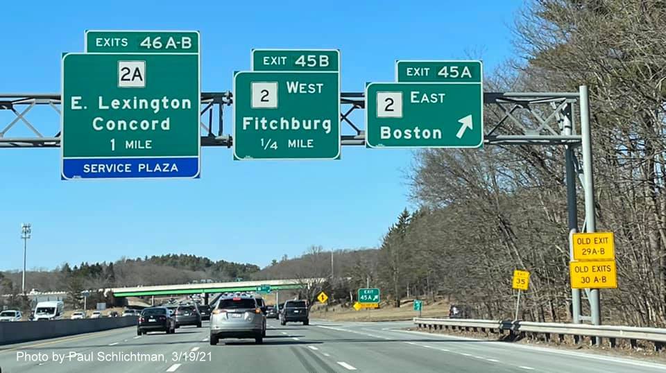 Image of overhead advance signs for MA 2 exits with new milepost based exit numbers and yellow Old Exit advisory signs on right support on I-95/MA 128 North in Lexington, photo by Paul Schlictman, March 2021