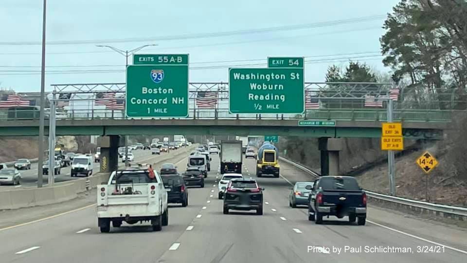 Image of 1/2 Mile advancie overhead sign Washington Street exit with new milepost based exit number and yellow Old Exit signs on right support on I-95/MA 128 North in Woburn, by Paul Schlichtman, March 2021