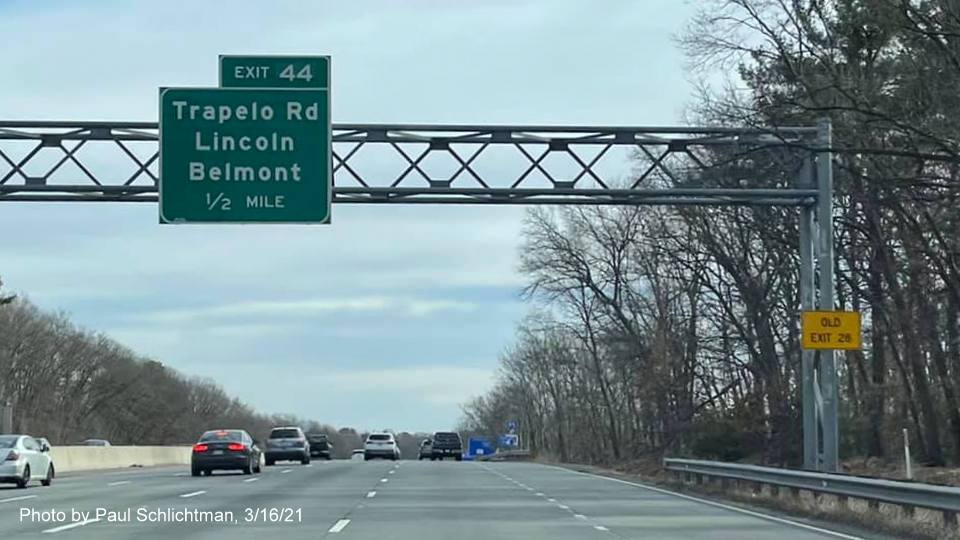 Image of 1/2 Mile advance overhead sign for the Trapelo Road exit with new milepost based exit number and yellow Old Exit 28 sign on right support on I-95/MA 128 South in Lexington, photo by Paul Schlictman, March 2021