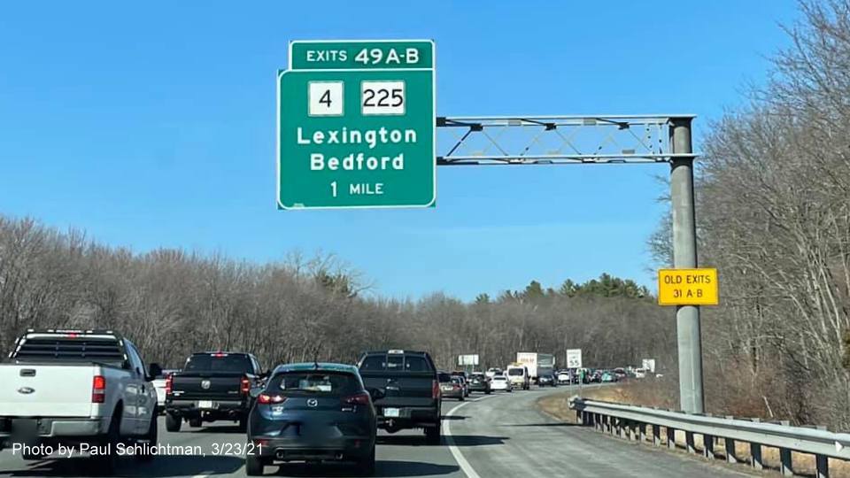 Image of 1 mile advance overhead sign for MA 4/225 exits with new milepost based exit numbers and yellow Old Exits 31 A-B advisory sign on support on I-95/MA 128 North in Lexington, by Paul Schlichtman, March 2021