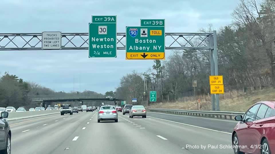 Image of advance signage for MA 30 and I-90 exits with new milepost based exit numbers and yellow Old Exits 25 and 24 advisory signs on right support on I-95/MA 128 South in Weston, by Paul Schlichtman, April 2021